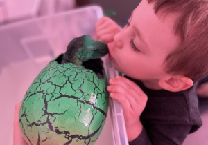 chłopiec całuje małego dinozaura